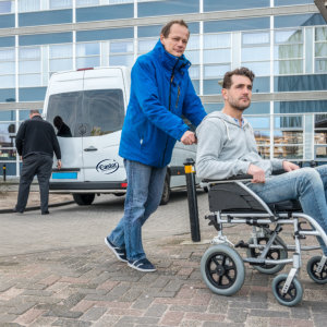 Senior man helping disabled man to attend appointment