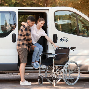 Man helping woman to get in wheelchair