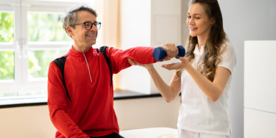 nurse helping patient to carry dumbells