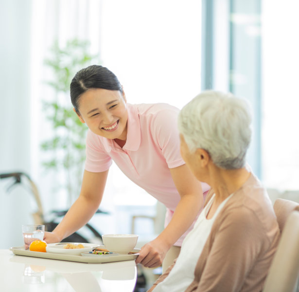 caregiver preparing meal fo senior woman