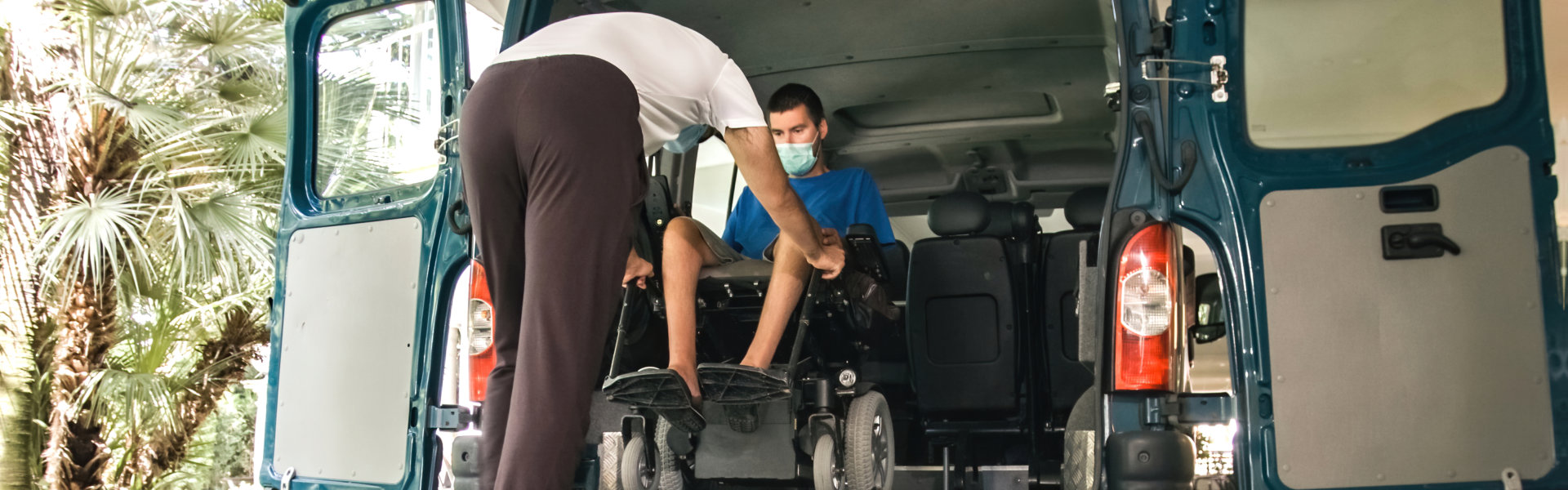 Man helping young man to get inside the van