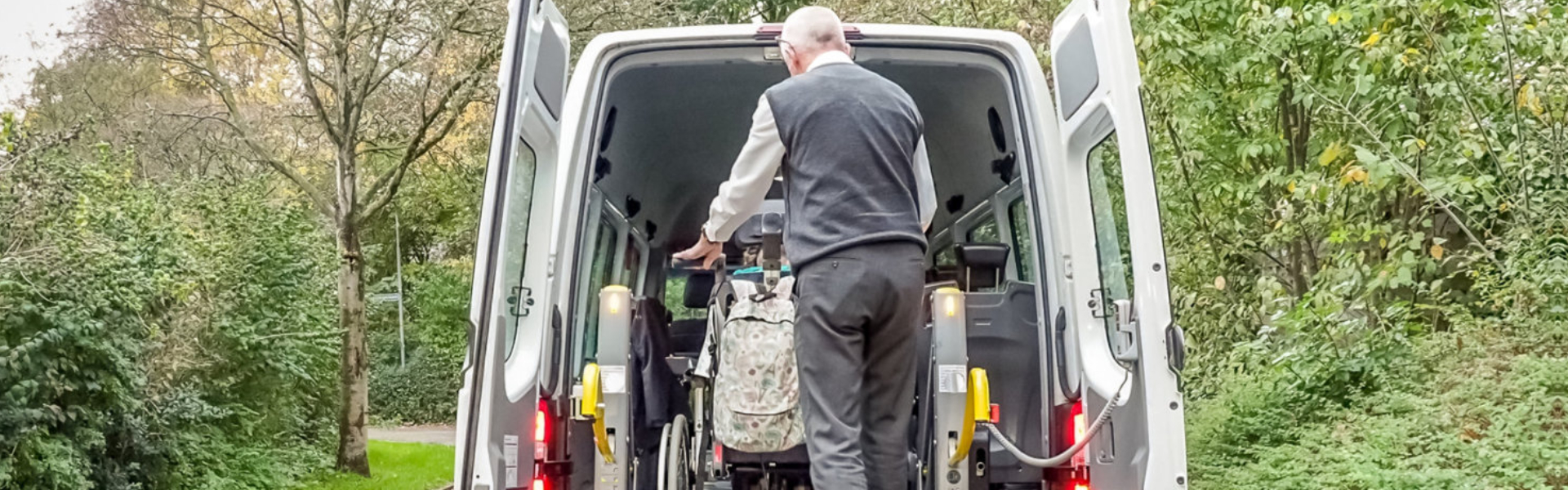 Driver assisting patient get into the van