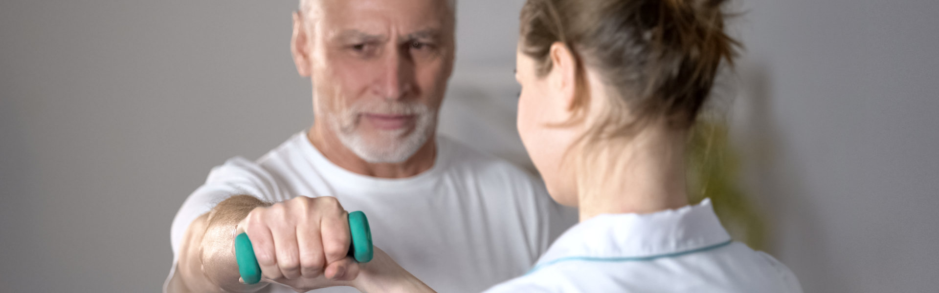 caregiver helping senior man with his work out