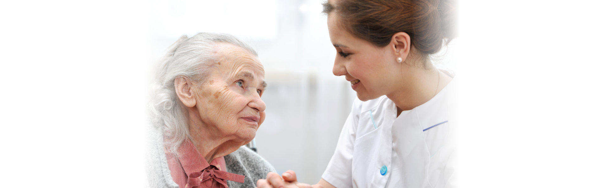 senior and caregiver looking at each other